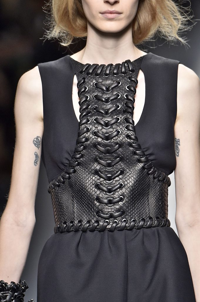 Schwarzes Kleid mit geflochtener Lederapplikation