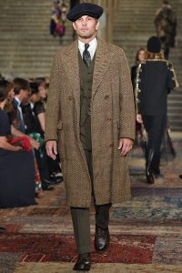 Model trägt langen Mantel aus Tweed-Stoff.