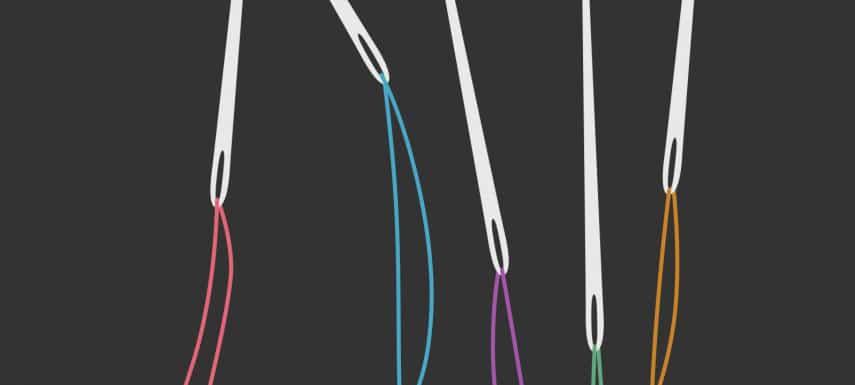Vier verschiedene Nähnadeln mit Faden
