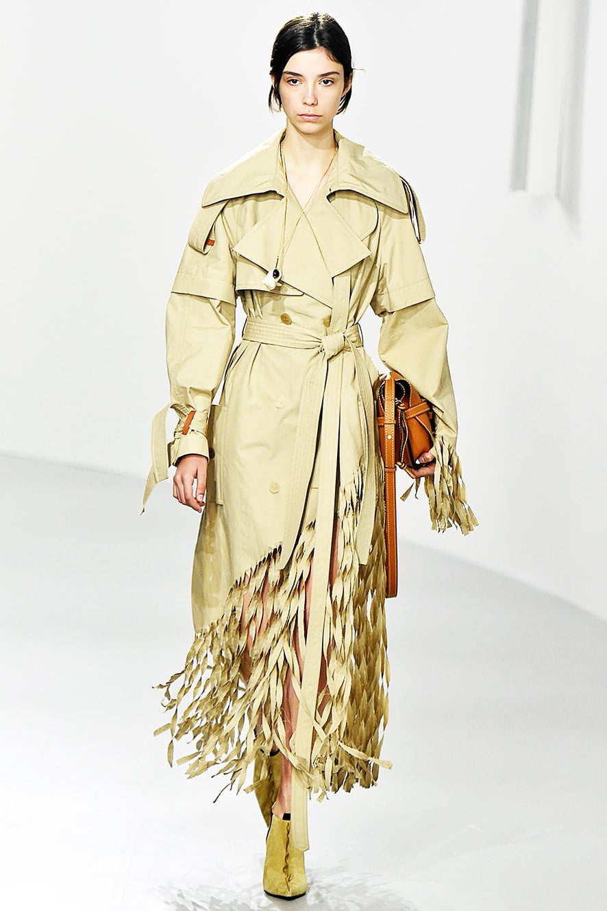 Das Foto zeigt ein Model auf dem Catwalk die einen Trenchcoat trägt. Die Fotos dienen als Vorlage für den Schnitt auf dem Schnittmusterbogen